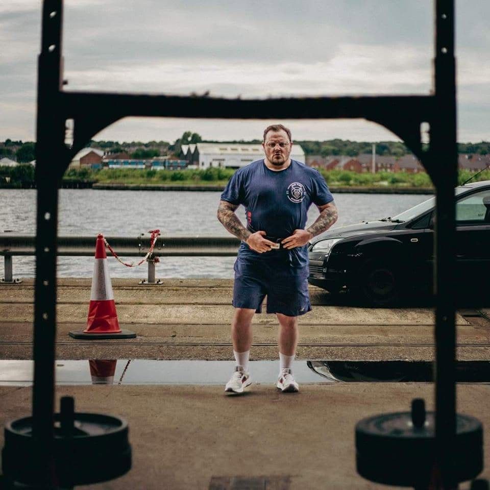 Vinny Jones by the dock, framed through a rack